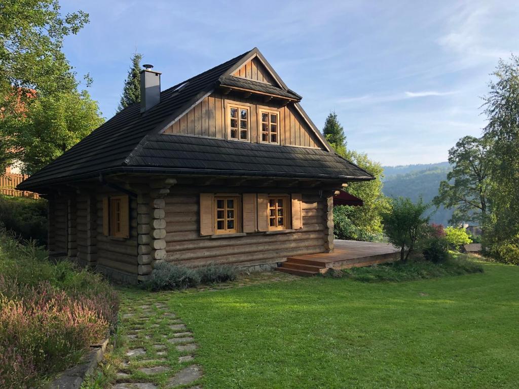 una pequeña cabaña de madera en un campo de hierba en Resetówka - w dzień wyjazdu zostań do wieczora, en Brenna