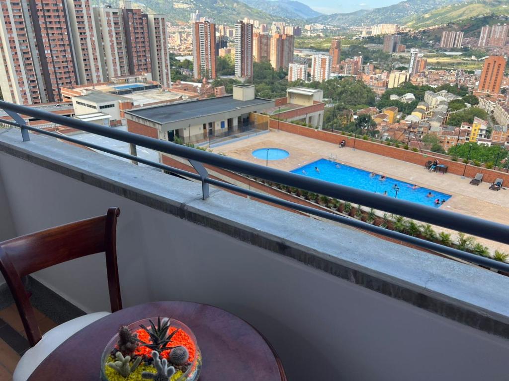 d'un balcon avec une table et une vue sur la piscine. dans l'établissement Hermoso Apto con Vista al Ciudad y Parqueadero Gratis, à Bello