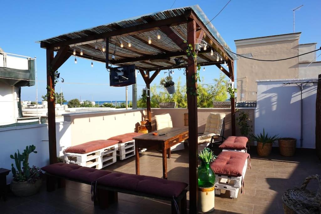 une pergola en bois avec une table et des bancs sur un toit dans l'établissement Martina&Simone, à Campomarino