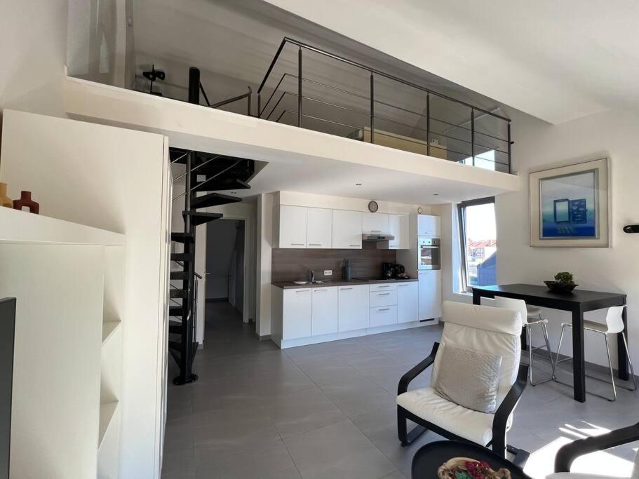 a living room and kitchen with a staircase in a house at Alexa Residence - Appartement 2 in Roeselare