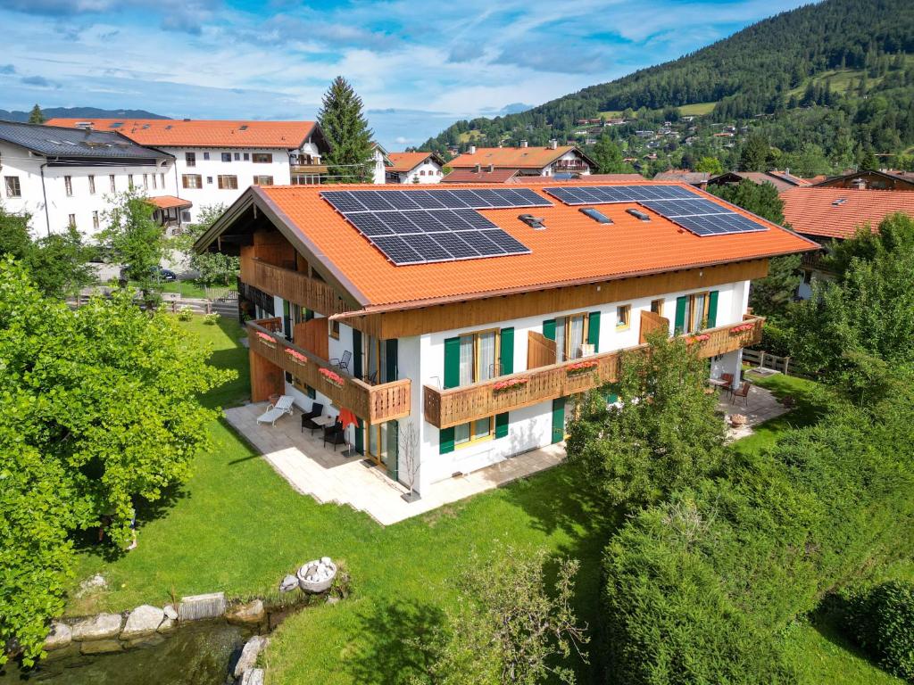 eine Luftansicht eines Hauses mit Sonnenkollektoren auf dem Dach in der Unterkunft Gästehaus Maier zum Bitscher in Rottach-Egern