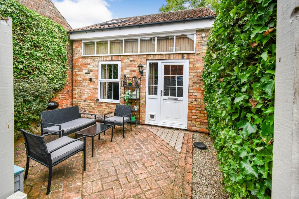 a patio with chairs and a white door at Fifth Milestone Annexe in York