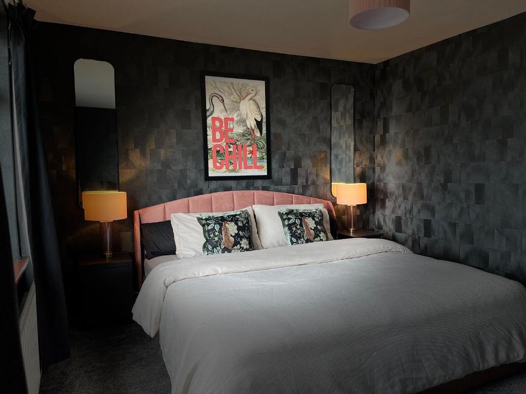 a bedroom with a large bed and two lamps at The Heather Dew in Portstewart