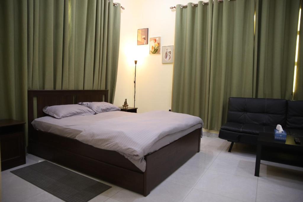 Luxury private Studio apartment close to Airport في أبوظبي: غرفة نوم بسرير واريكة وكرسي