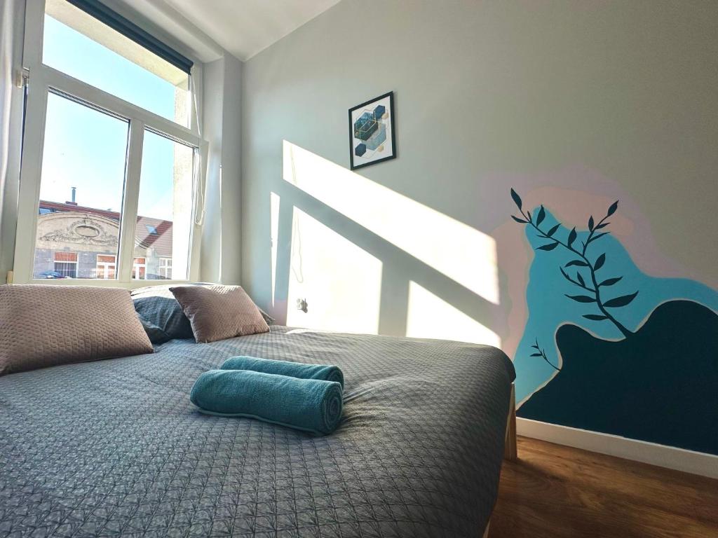a bedroom with a bed with a blue pillow on it at MMRent Botanic Room in Gdańsk