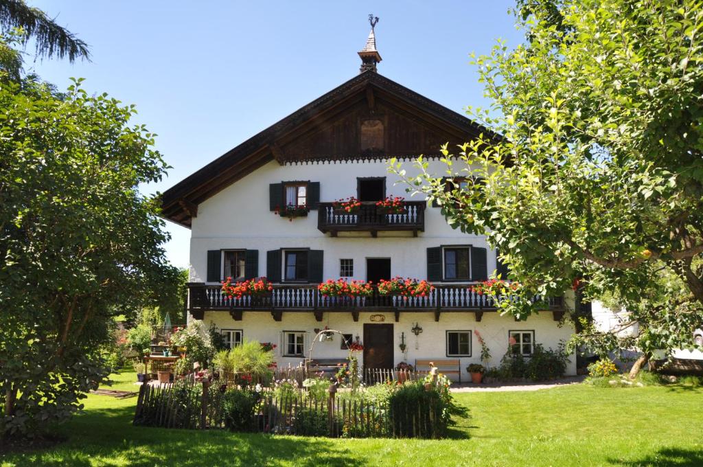 una gran casa blanca con flores en el balcón en Melchambauer, en Maria Alm am Steinernen Meer
