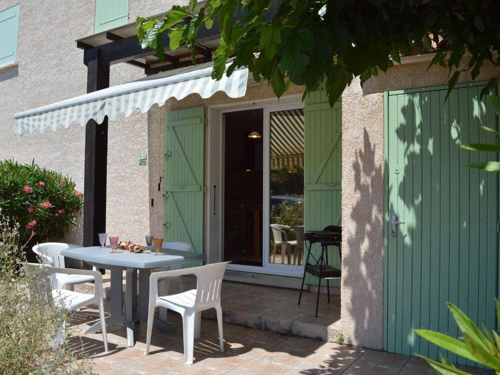 une table et des chaises assises à l'extérieur d'un bâtiment dans l'établissement Pavillon climatisé 2 pièces mezzanine, terrasse, parking, 900m plage – Saint-Pierre-la-Mer - FR-1-229D-65, à Fleury