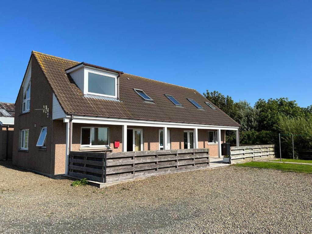 a house with a porch and a roof at Tangles & Kelpie in Burray Village