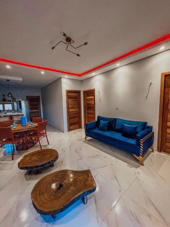 ein Wohnzimmer mit einem blauen Sofa und einem Tisch in der Unterkunft Chill House Praia do Preá-CE in Prea