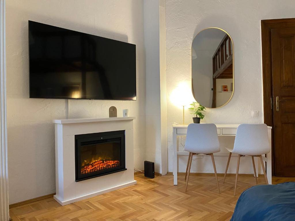 uma sala de estar com lareira e uma televisão por cima em Cozy & stylish city centre flat em Budapeste