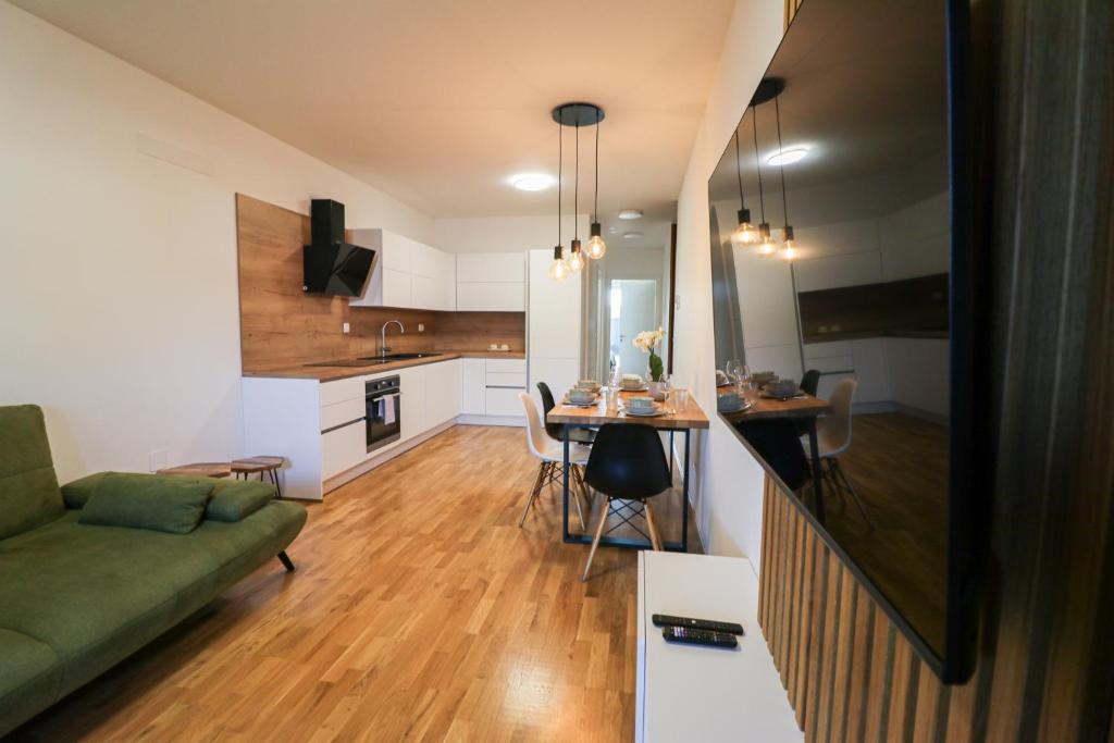 sala de estar y cocina con sofá y mesa en Apartment LaSiesta II, en Ptuj