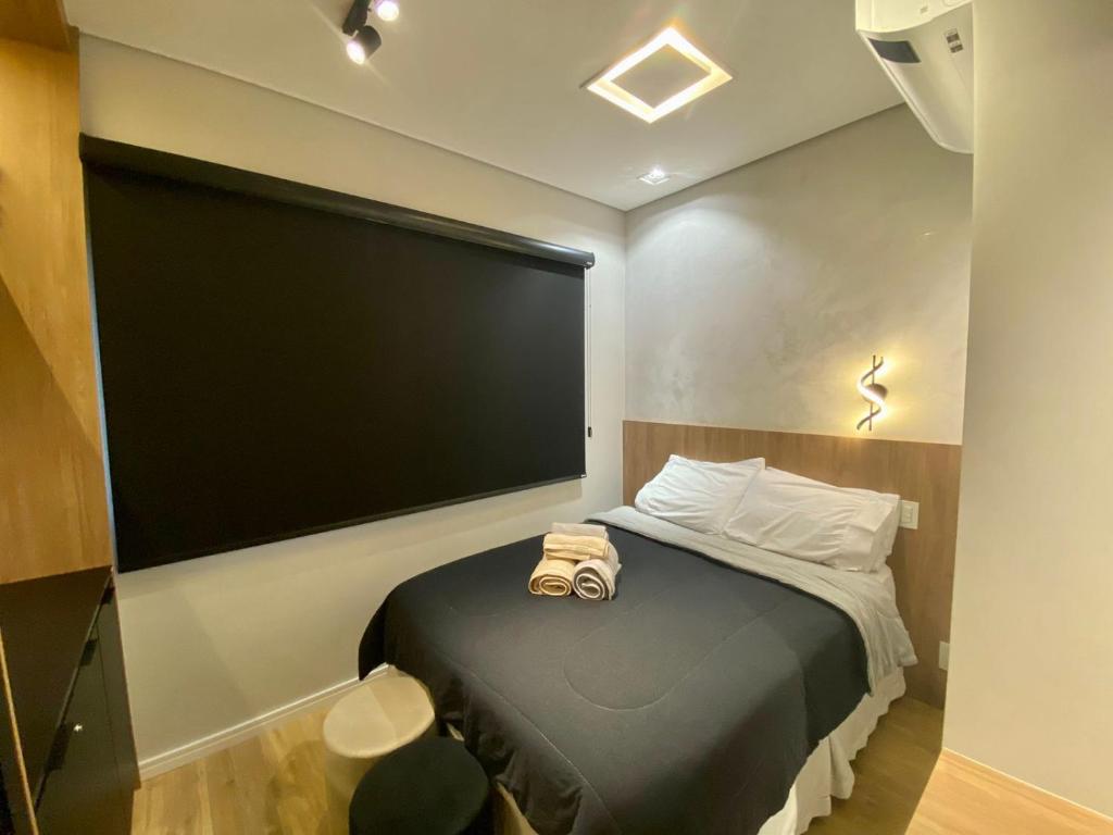 um quarto com uma cama com um grande ecrã na parede em loft luxuoso Home & Lifestyle Ibirapuera. N.946 em São Paulo
