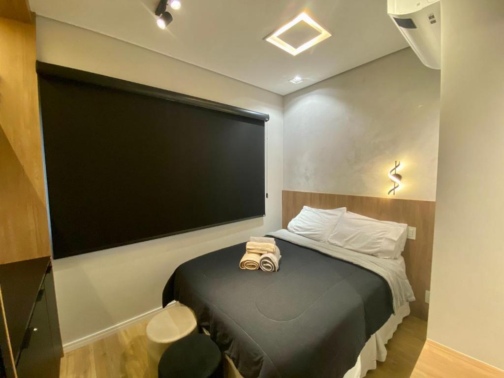 a room with a bed with a large screen on the wall at loft luxuoso Home & Lifestyle Ibirapuera. N.946 in Sao Paulo