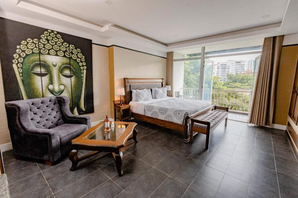 um quarto de hotel com uma cama e uma cadeira em Hotel Du Parc em Medellín