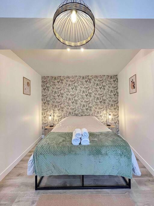 - une chambre dotée d'un lit avec une paire de chaussures dans l'établissement L'Amazonite - Romans, à Romans-sur-Isère