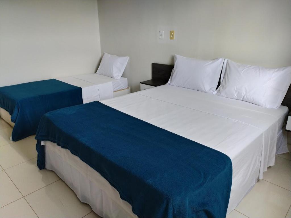 2 Betten mit blauer und weißer Bettwäsche in einem Zimmer in der Unterkunft Maper Park Carajás in Parauapebas