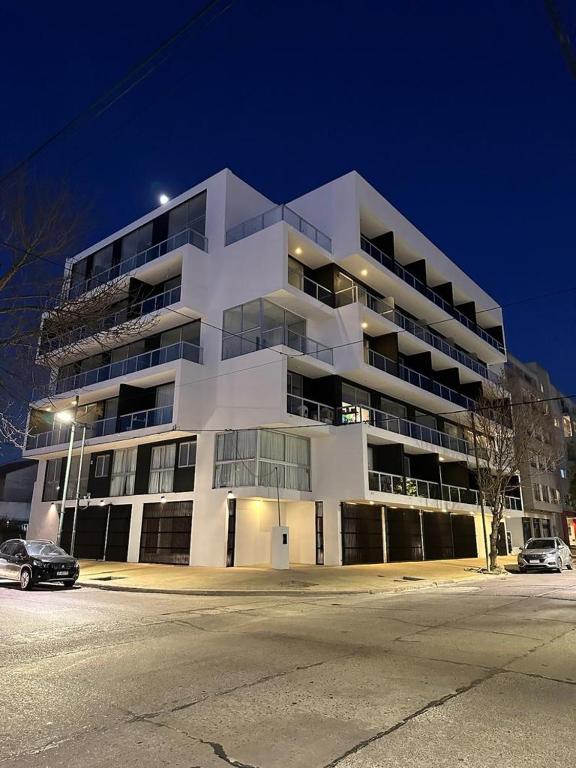 a large white building with cars parked in front of it at Monoambiente 50 y 28 in La Plata