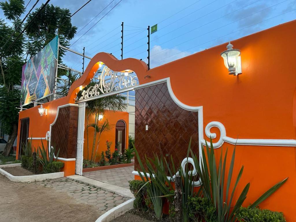 ein orangefarbenes Gebäude mit einem Tor davor in der Unterkunft Alojamientos OHANA in Oaxaca de Juárez