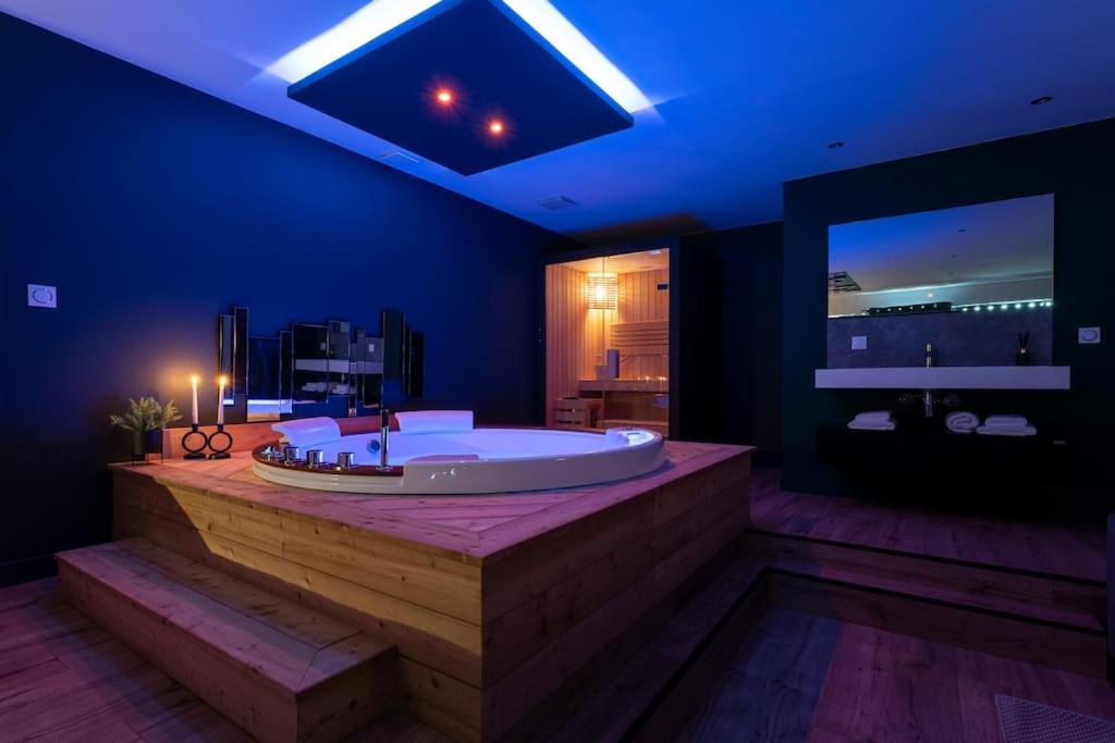 a large bathroom with a large tub with blue lighting at Loveroom Lens in Lens