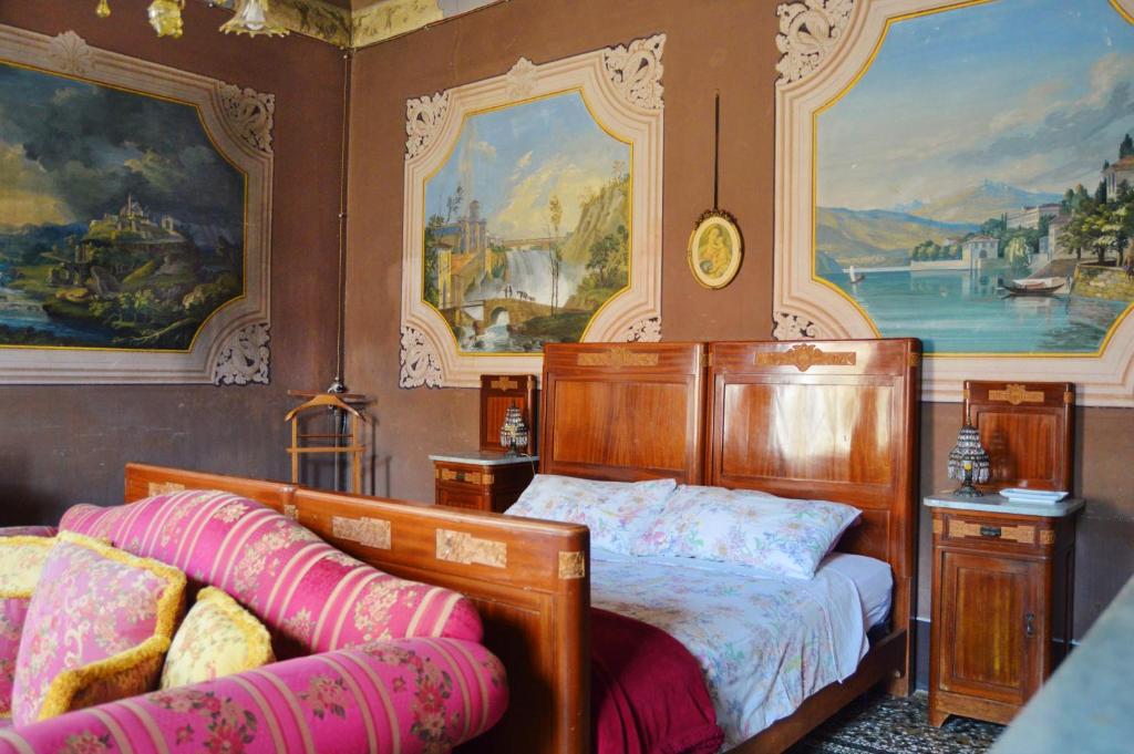 a bedroom with a bed and paintings on the wall at Palazzetto Scodellari in San Vito al Tagliamento