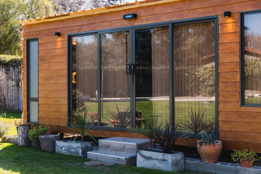 a house with glass doors and plants in a yard at Tiny House in Mendoza