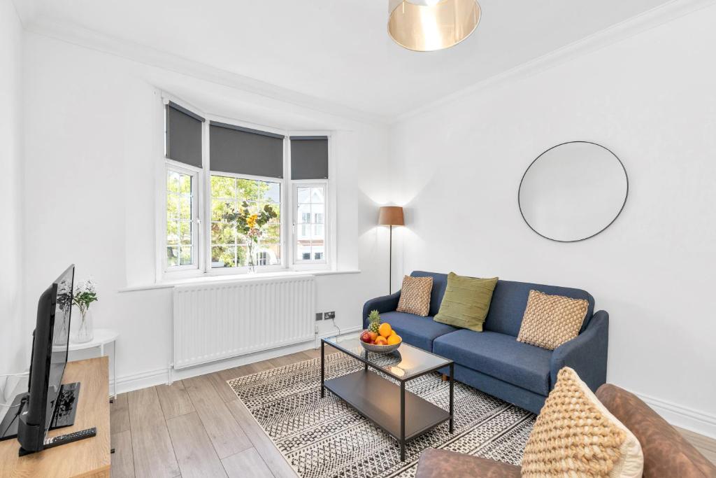a living room with a blue couch and a tv at Modern Two Bedroom Apartment with Free Parking! in London