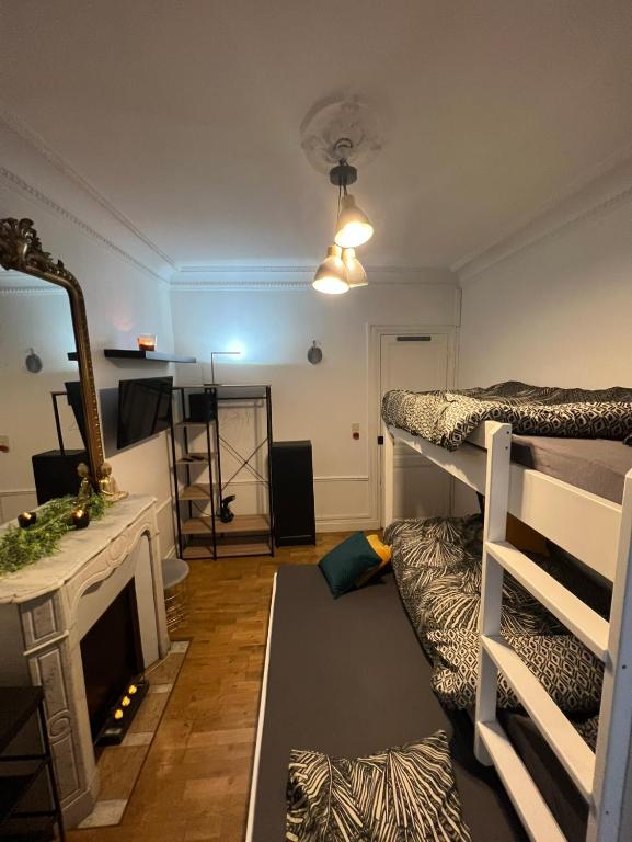 Cette chambre comprend 2 lits superposés et une cheminée. dans l'établissement Charmant 3 pièces Champs-Elysées, Ternes, Porte Maillot, 17ème, à Paris