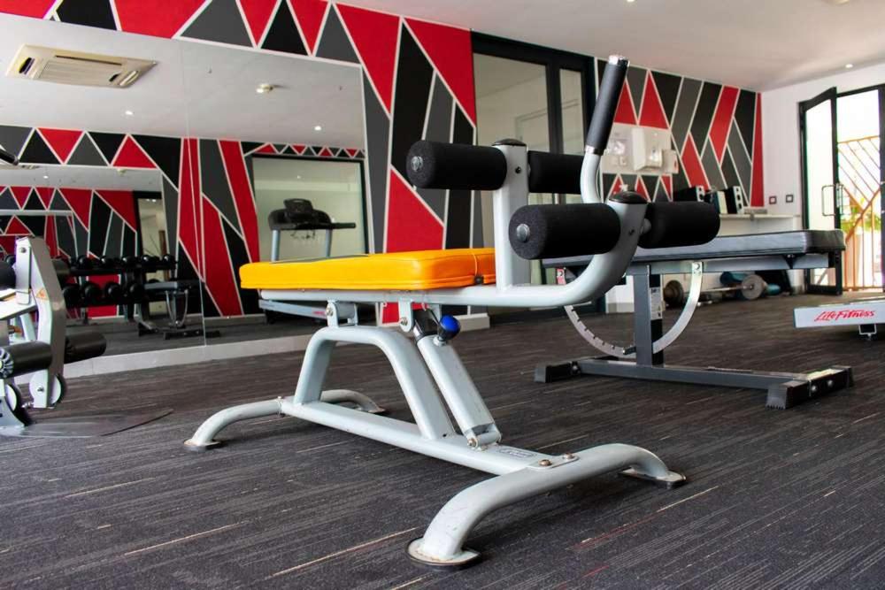 a gym with a bench in a gym with red and black walls at Beaufort Ridge 402 in Accra
