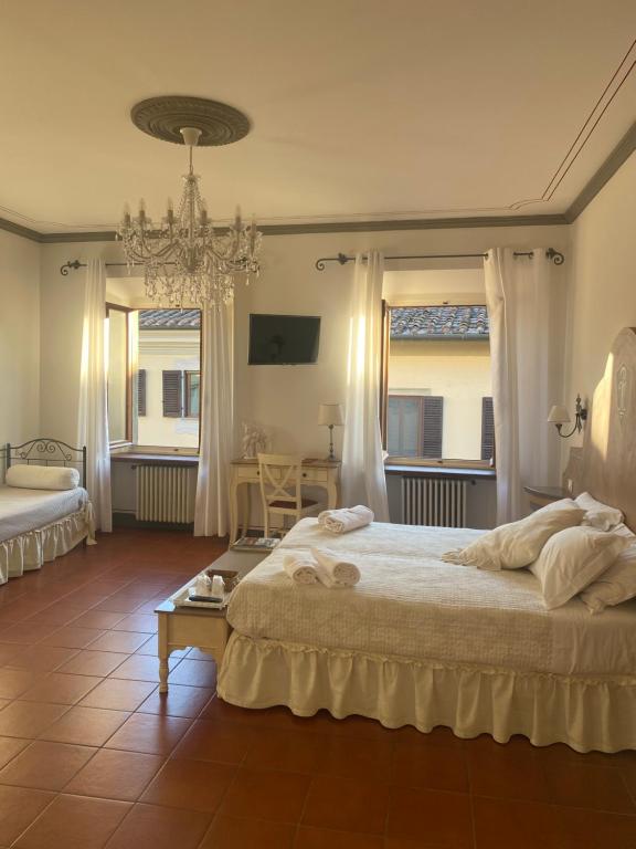 a bedroom with a large bed and a chandelier at Palazzo Mari suite & rooms b&b in Montevarchi