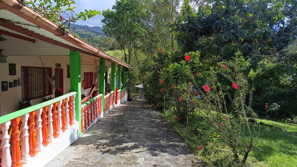 una casa con una valla naranja y verde y flores en Finca Hotel Spa Zhay, en Tibirita
