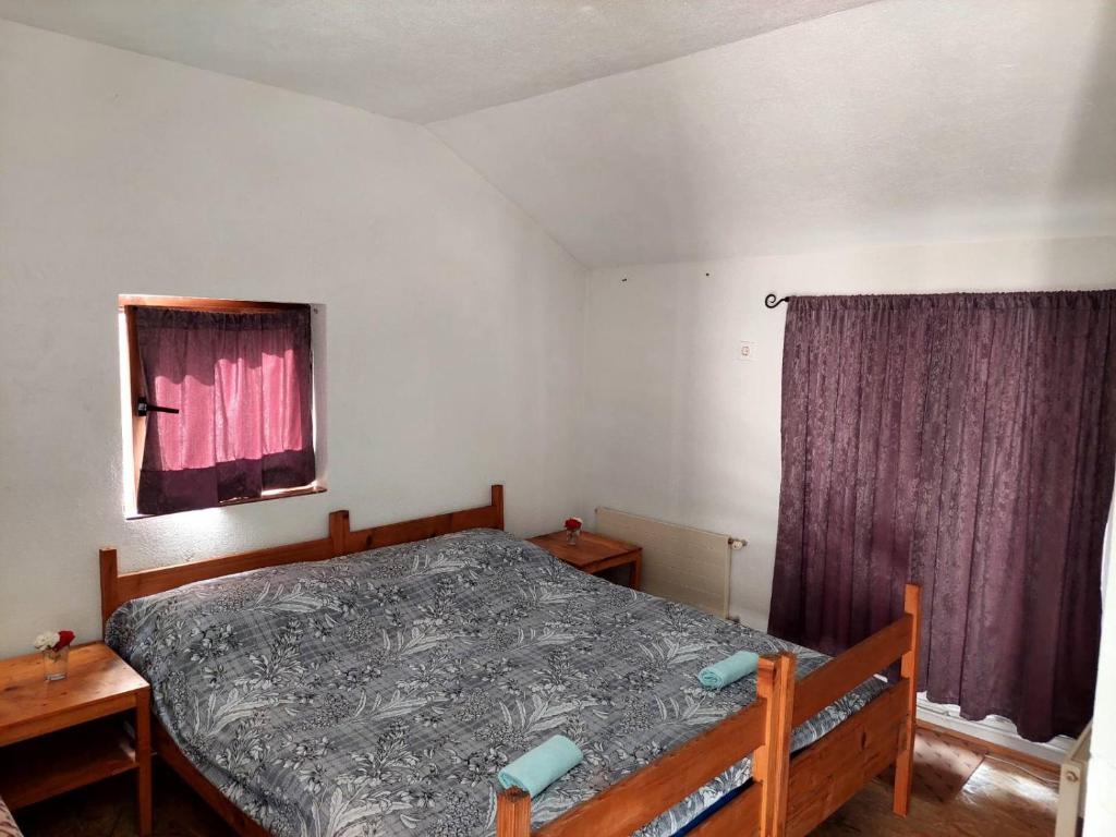 特拉夫尼克的住宿－33 Lipe，一间卧室配有一张床和一个带紫色窗帘的窗户