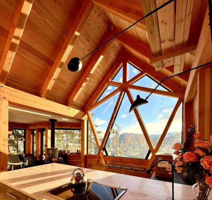 a room with a large window in a cabin at Basecamp Strathcona Park View Chalet in Mount Washington