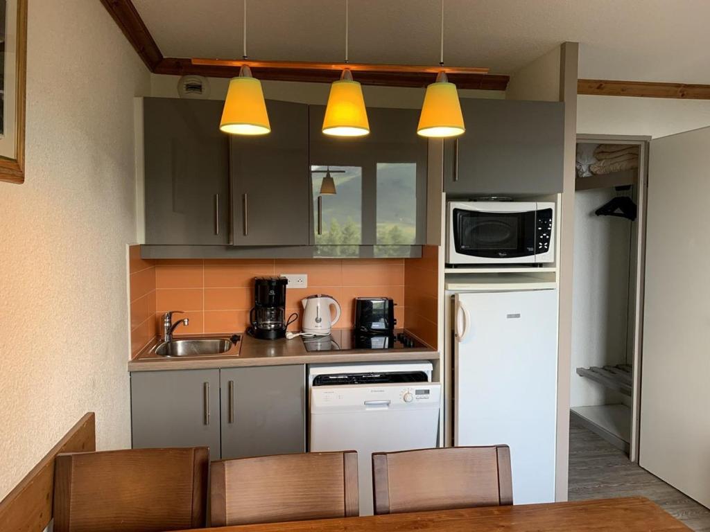 una pequeña cocina con fregadero y nevera. en Appartement Huez, 2 pièces, 6 personnes - FR-1-405-211, en LʼHuez