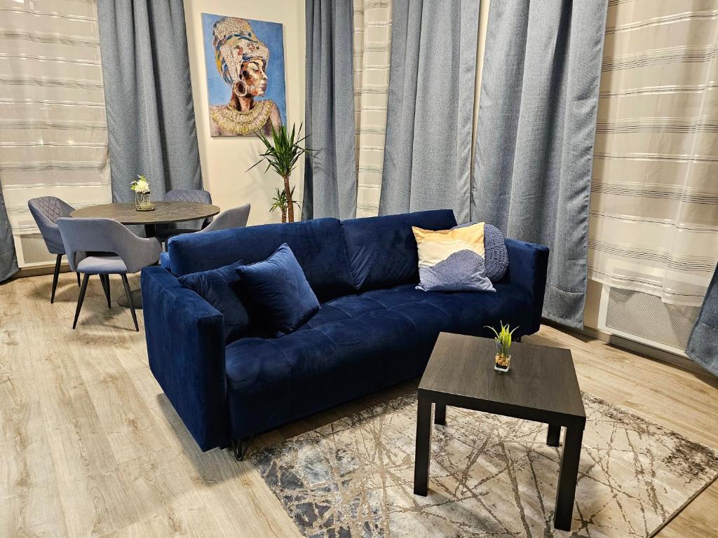 ein Wohnzimmer mit einem blauen Sofa und einem Tisch in der Unterkunft Luxusní apartmán 3KK u náměstí - Klicperova in Hradec Králové
