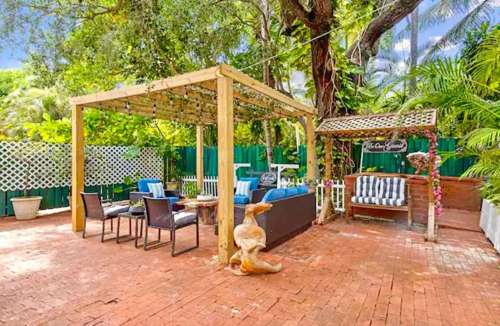 een patio met een tuinhuisje met stoelen en een tafel bij Coconut Grove, Miami FL in Miami