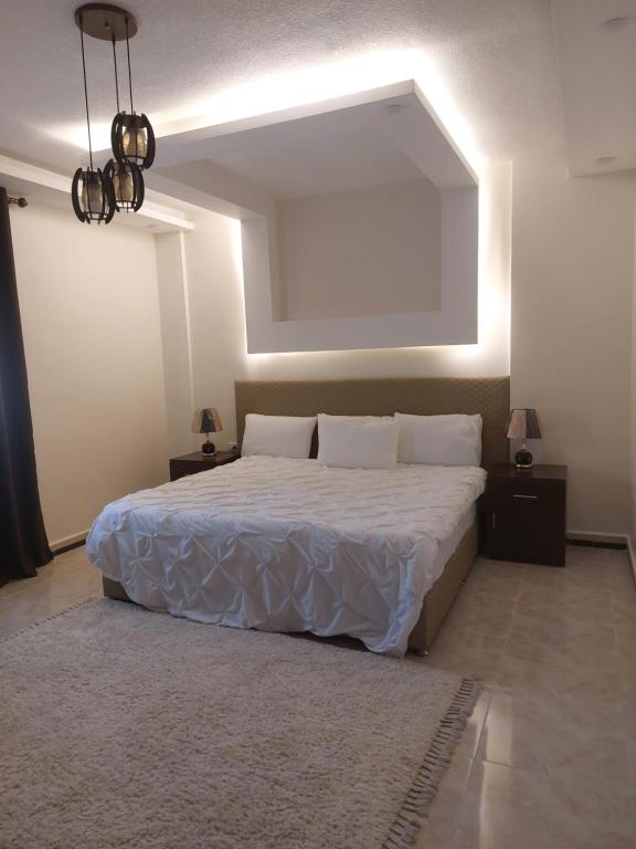 een slaapkamer met een groot wit bed in een kamer bij Petra Guests home in Wadi Musa
