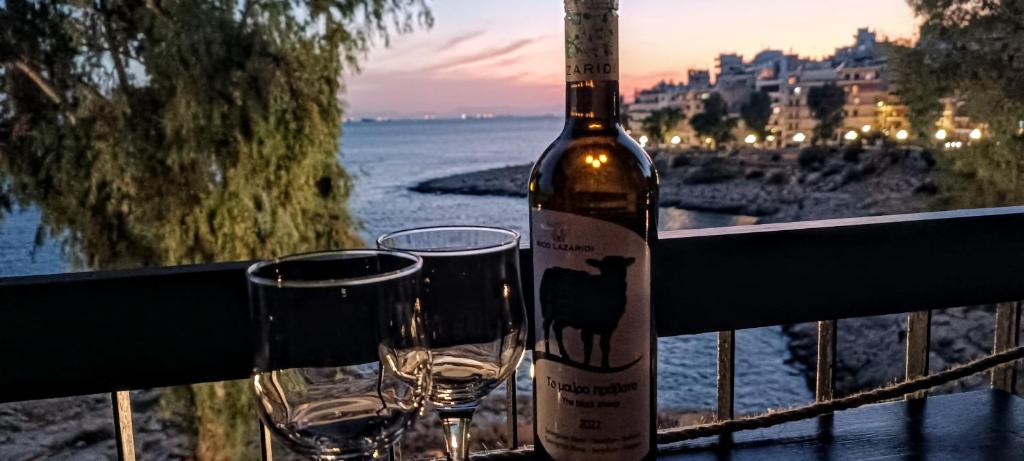 a bottle of wine and two glasses on a balcony at Sea Luxury Apartments in Piraeus