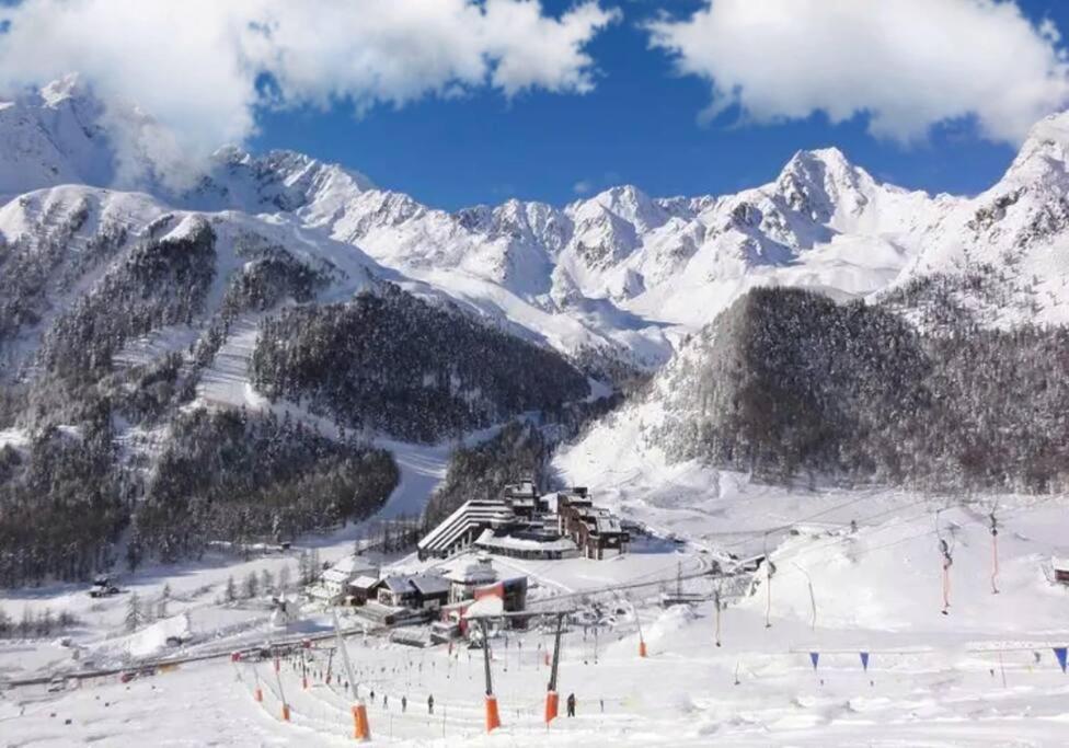 un lodge de esquí en una montaña nevada con montañas cubiertas de nieve en Maso Corto Intero Appartamento, en Maso Corto