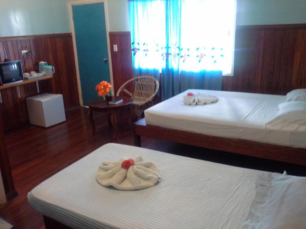 una habitación de hotel con 2 camas y toallas en una mesa en Rekona Lodge en Gizo