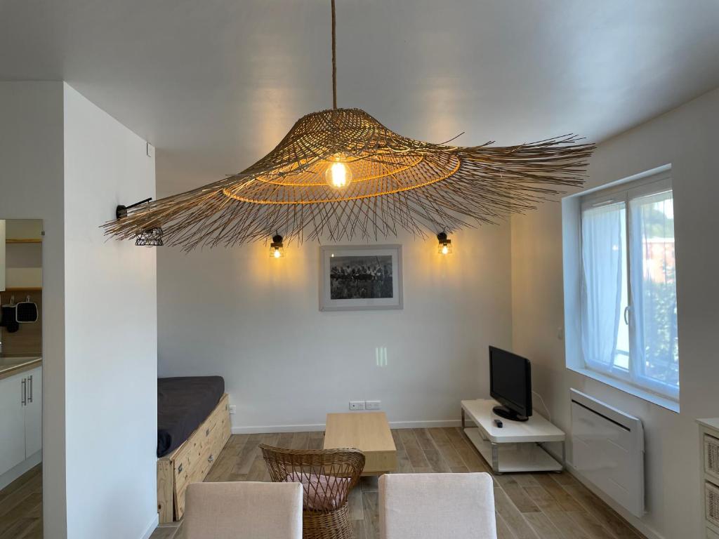 a living room with a large chandelier hanging from the ceiling at AlloAppartMeuble StPol in Saint-Pol-sur-Ternoise