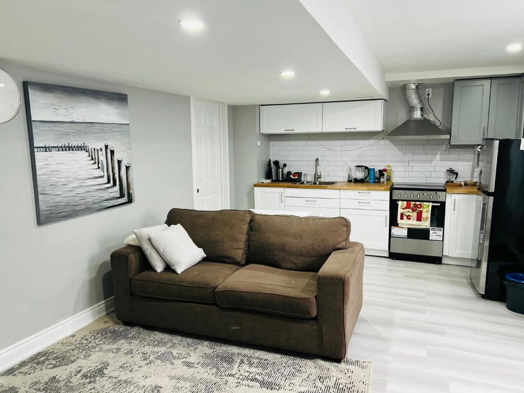 sala de estar con sofá y cocina en Cozy 1 BR basement apartment with Free Street Parking & Separate Entrance, en Milton