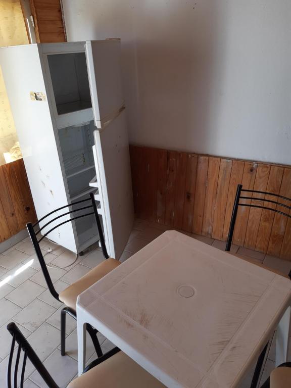 una mesa blanca y sillas en una habitación con puerta en Dptos Rio Neuquen en 