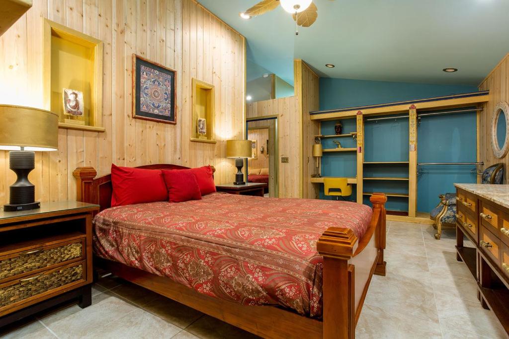 a bedroom with a bed with red pillows in it at Hawaiian Asian Vacation House in Pahoa