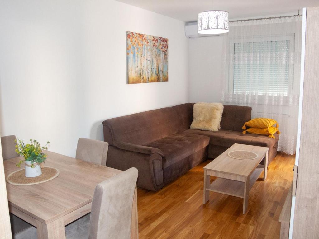 sala de estar con sofá marrón y mesa en Apartman Valerija, en Doboj