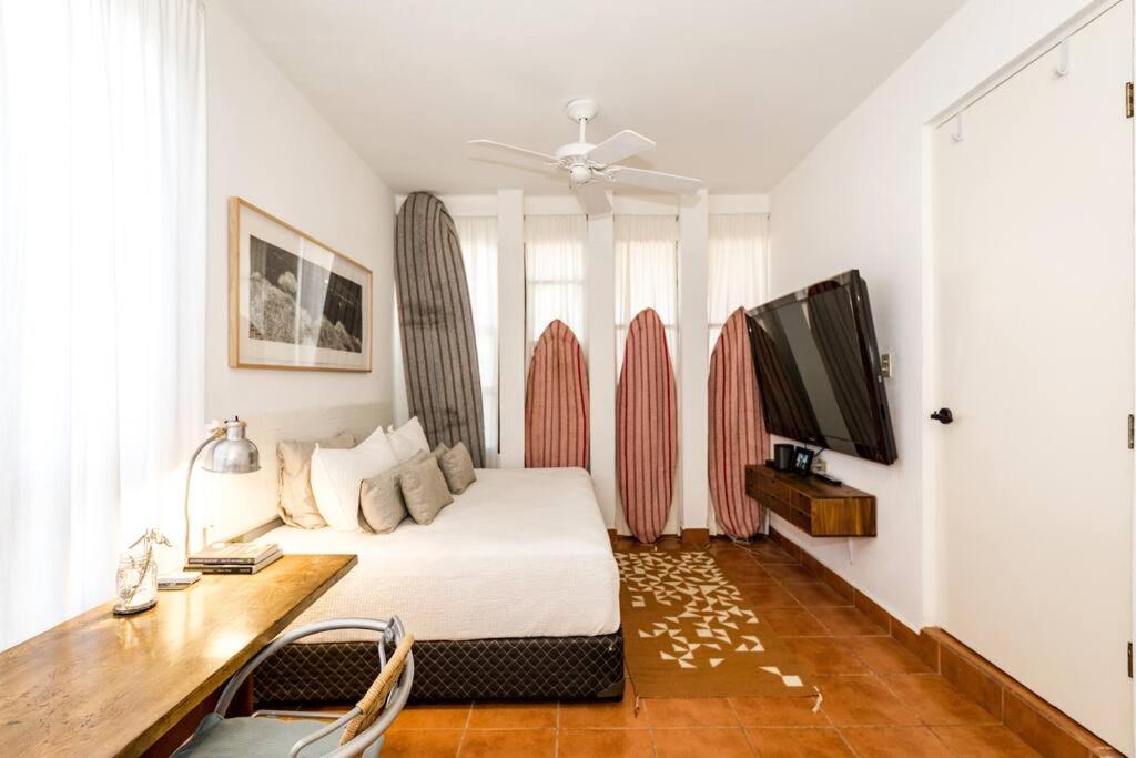 a bedroom with a bed and a desk and a tv at Authentic Loft Retreat Steps from Beach & Culture in San José del Cabo