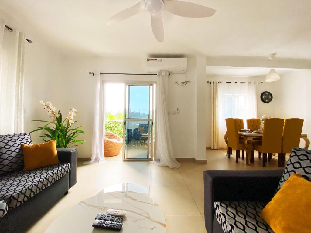 uma sala de estar com um sofá e uma mesa em Residence Atlantic - Premium Apartment - WiFi, Gardien, Parking, Climaté em Douala