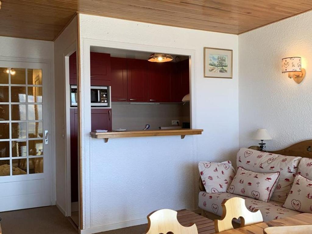 un salon avec un canapé et une cuisine dans l'établissement Charmant studio 4 pers. 32 m², balcon Sud, télésiège à 50m – Alpe d’Huez - FR-1-405-222, à Huez