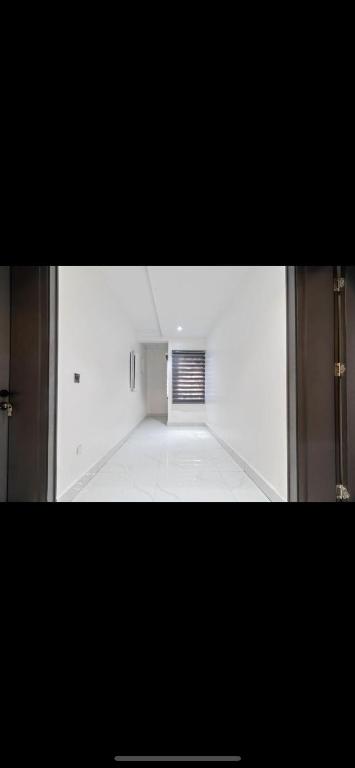 Habitación vacía con suelo blanco y ventana en Kaf lag apartment en Lekki