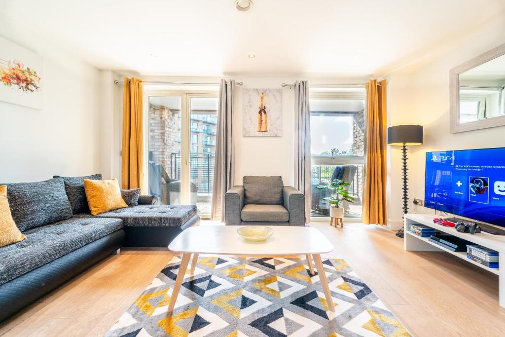 a living room with a couch and a table at Luxury Greenwich 2Bed 2Bath Apt - Sleep 6 Guest- 1 min from station - close to Greenwich Maritime- Playstation provided in London