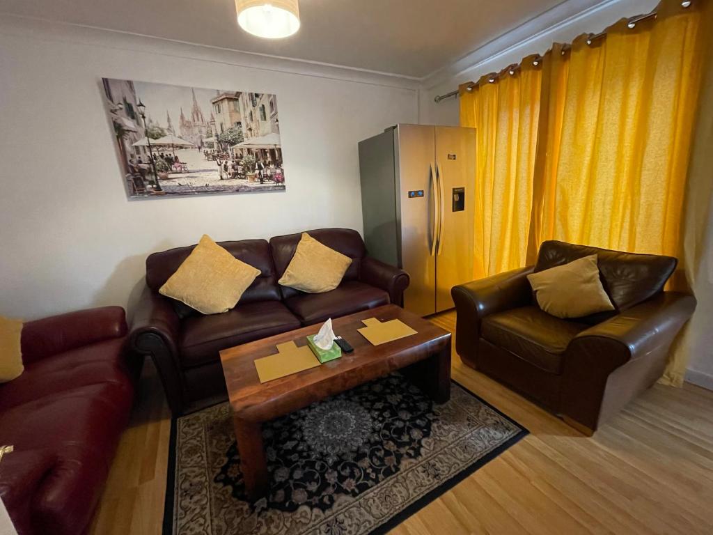 a living room with two couches and a coffee table at Holiday Home Cardiff City Sleeps 7 in Cardiff